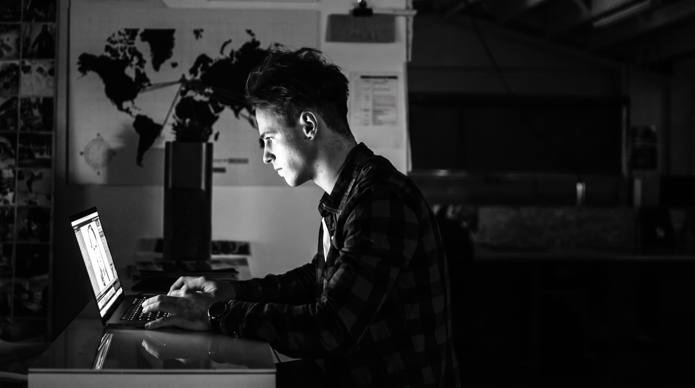 A creator working late at night on their laptop, building something of their own