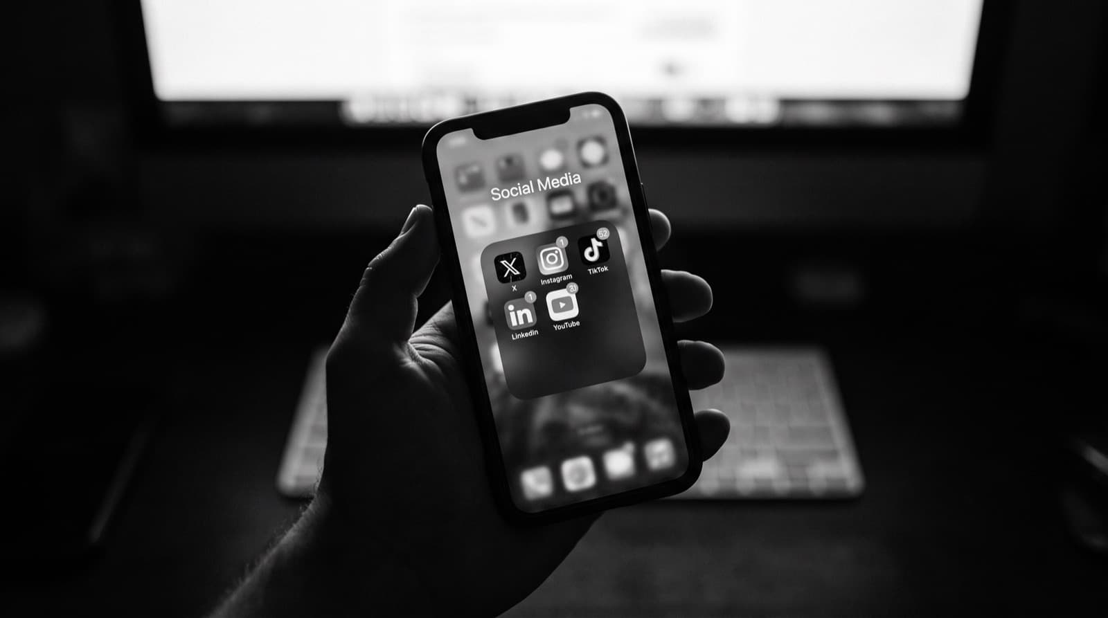 A creator holding a phone open to their social media apps